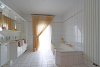 Badkamer met ligbad, douche, dubbele lavabo en toilet