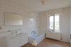 Badkamer met ligbad en enkele wastafel in badkamermeubel