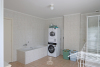 Badkamer met ligbad, douche en enkele wastafel in badkamermeubel 