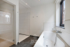 Badkamer met ligbad, douche en dubbele lavabo in modern badkamermeubel 