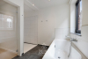 Badkamer met ligbad, douche en dubbele lavabo in modern badkamermeubel 